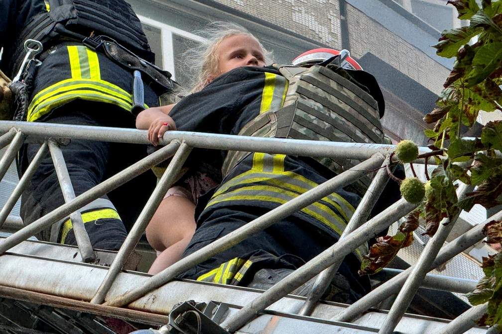 Criança sendo retirada por bombeiros de prédio em chamas — Foto: REUTERS/Vitalii Hnidyi