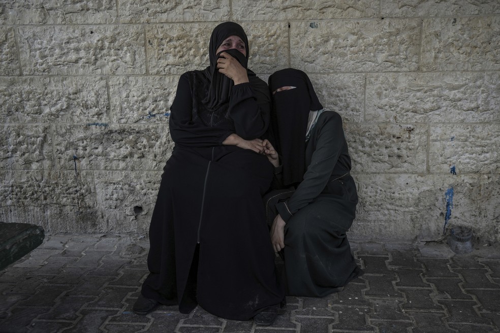 Palestinas choram pela morte de parentes em ataque israelense na Faixa de Gaza em durante a guerra. — Foto: AP Photo/Abdel Kareem Hana