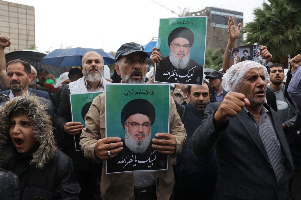 Iranianos se reúnem em Teerã segurando cartazes com o retrato de Hassan Nasrallah, líder do grupo extremista Hezbollah — Foto: Majid Asgaripour/WANA (West Asia News Agency) via Reuters