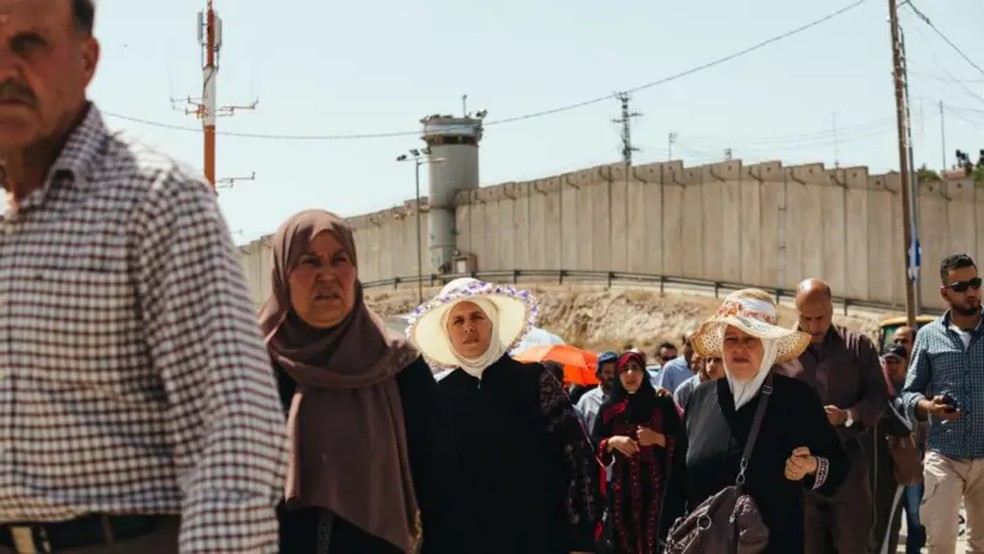 Palestinos cruzam posto de controle de Qalandiya, ao sul de Ramallah, Cisjordânia — Foto: Fonte: Getty Images/BBC