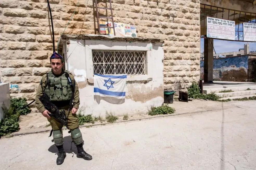 Soldado israelense guarda a entrada de um assentamento judeu em Hebron, na Cisjordânia — Foto: Foto: Getty Images/BBC