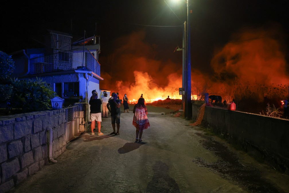 Moradores do povoado de Canas de Senhorim, perto de Viseu, no centro de Portugal, observam chamas que se aproximam das casas, em 16 de setembro de 2024. — Foto: Pedro Nunes/ Reuters