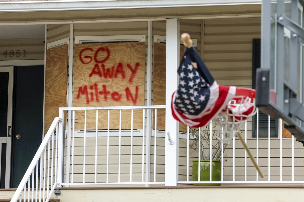 Casa reforçada com madeira em Port Richey, na Flórida, para a chegada do furacão Milton em 7 de outubro de 2024. Na maneira, está escrito "vá embora, Milton". — Foto: AP Photo/Mike Carlson
