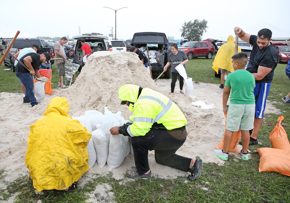 Moradores de Kissimmee, na Flórida, enchem sacos de areia para proteção contra a tempestade Milton, que virou furacão — Foto: Gregg Newton/AFP