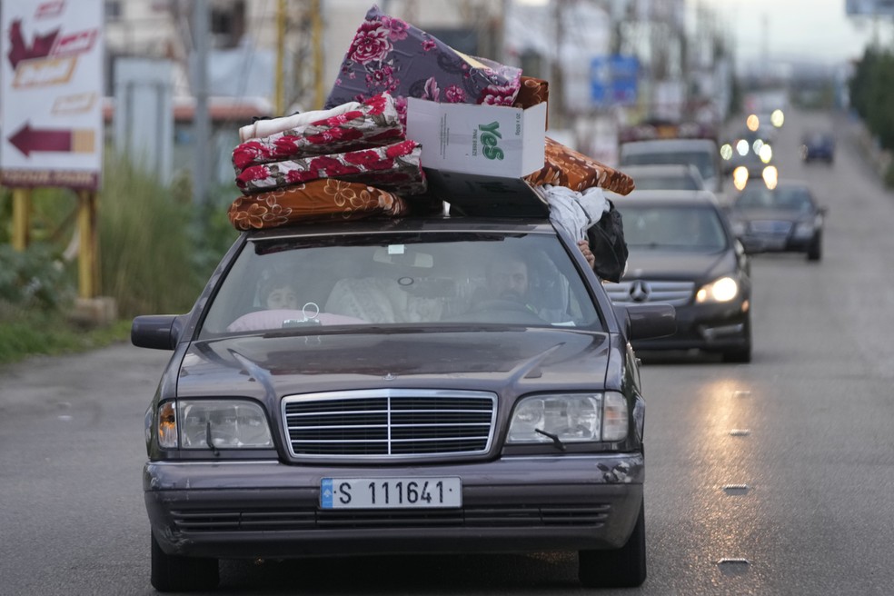 Pessoas em seus carros com pertences retornam para suas vilas após o início do cessar-fogo entre Hezbollah e Israel na madrugada de quarta-feira (27), em Tiro, no Sul do Líbano — Foto: Hussein Malla/AP