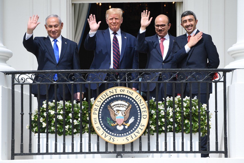 Setembro/2020 - O primeiro ministro israelense Benjamin Netanyahu, o presidente dos EUA Donald Trump, o ministro das relações exteriores do Bahrein Abdullatif al-Zayani e ministro das relações exteriores dos Emirados Árabes Unidos Abdullah bin Zayed Al-Nahyan acenam da varanda Truman, na Casa Branca, após a participação na assinatura dos Acordos de Abraham, onde os países do Bahrein e dos Emirados Árabes Unidos reconhecem Israel, em Washington, em 15 de setembro de 2020 — Foto: Saul Loeb/AFP/Arquivo