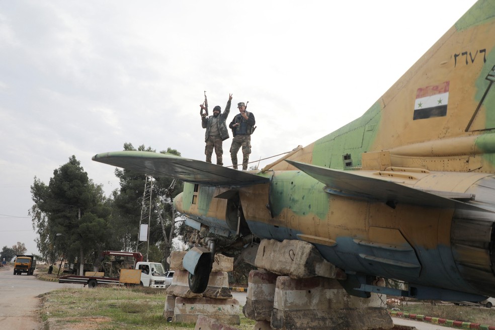 Rebeldes comemoram tomada de aeroporto militar na cidade de Hama, na Síria — Foto: Mahmoud Hasano/REUTERS