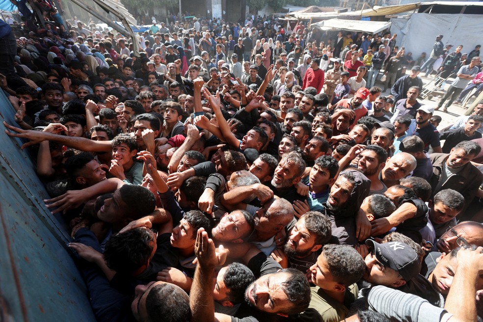 Homens se espremem em frente a padaria em Deir Al-Balah, na Faixa de Gaza — Foto: REUTERS/Ramadan Abed