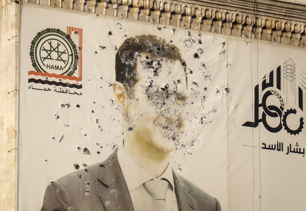 Imagem de Assad é alvo de vandalismo após queda do ditador na Síria — Foto: Omar Albam/AP