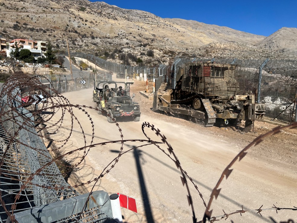 Soldados israelenses viajam em um veículo militar ao longo da linha de cessar-fogo com a Síria e as Colinas de Golã ocupadas por Israel, vistas das Colinas de Golã — Foto: REUTERS/Avi Ohayon