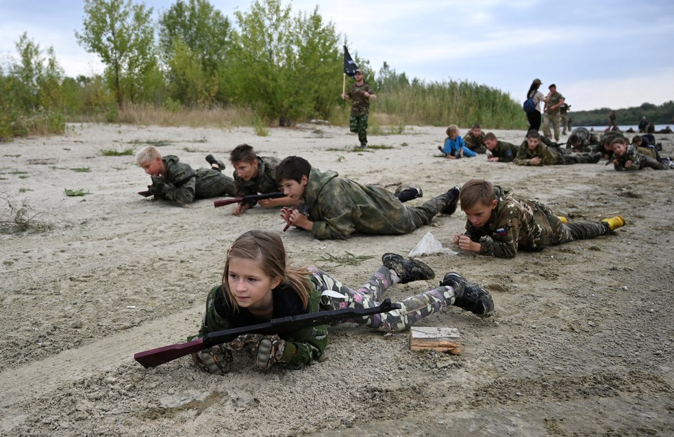 Crianças russas de 8 anos fazem 'treinamento' militar segurando AK-47 fake em Rostov, na Rússia, em 21 de agosto de 2025. — Foto: REUTERS/Sergey Pivovarov