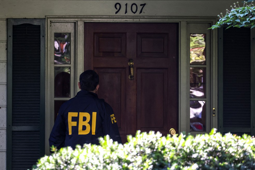 Agente do FBI na porta da casa do ex-agente de Segurança Nacional dos EUA, John Bolton, durante operação de buscas em sua residência, em 22 de agosto de 2025. — Foto: Tasos Katopodis/ Reuters