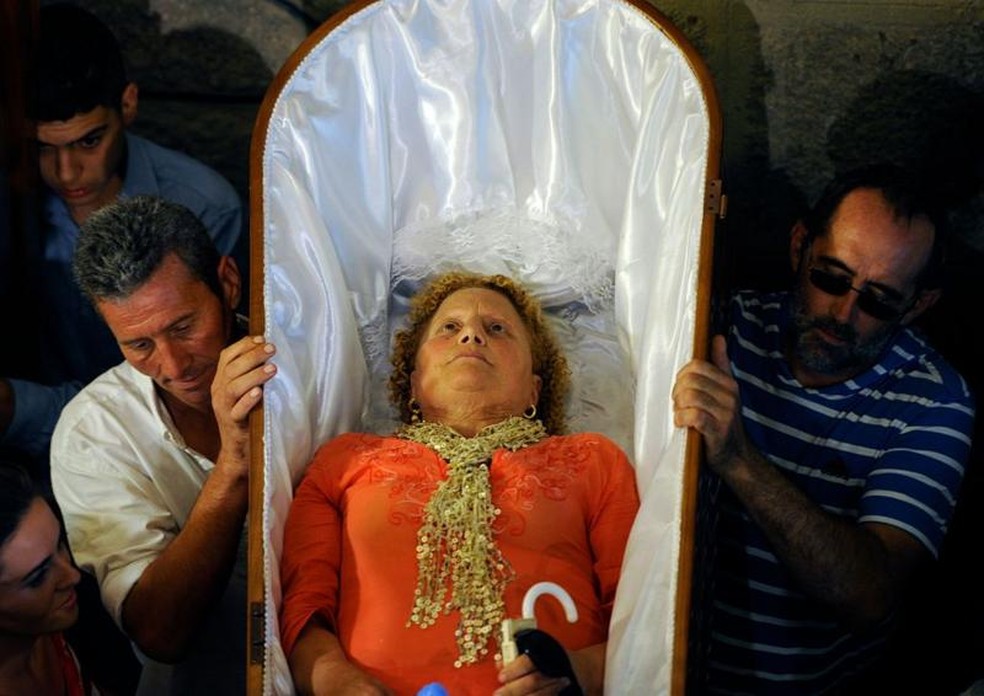 Os 'ofertados' são pessoas que estiveram à beira da morte ou tiveram pessoas próximas nessa situação. Eles se oferecem a Santa Marta para agradecer pela sua intervenção. — Foto: Miguel Riopa/AFP via Getty Images/BBC