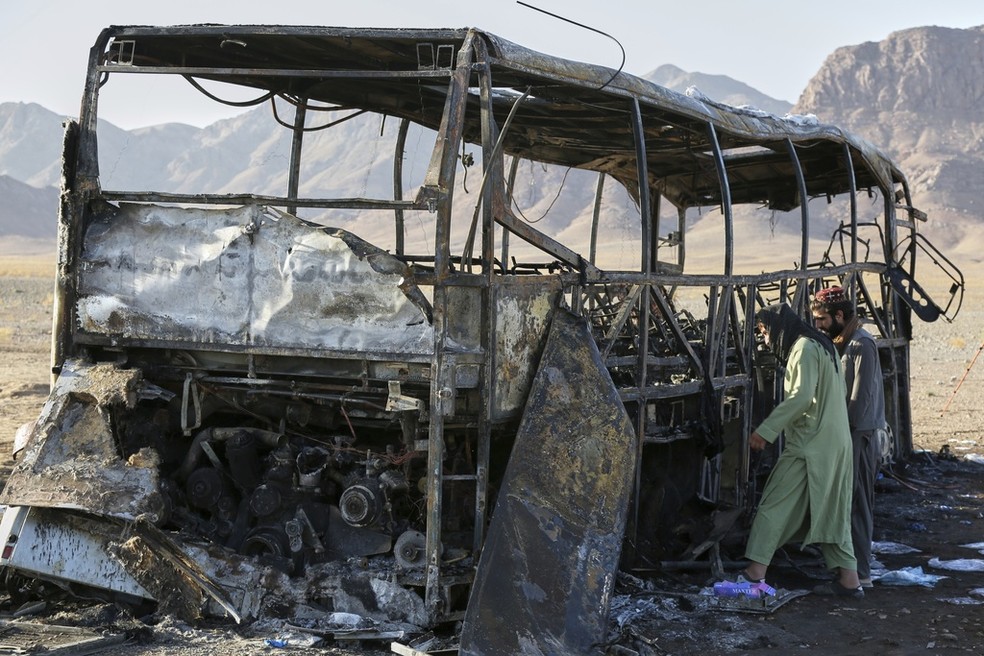 Estrutura de ônibus que transportava afegãos deportados do Irã após pegar fogo por conta de batida em estrada no norte do Afeganistão, em 20 de agosto de 2025. — Foto: Omid Haqjoo/ Reuters