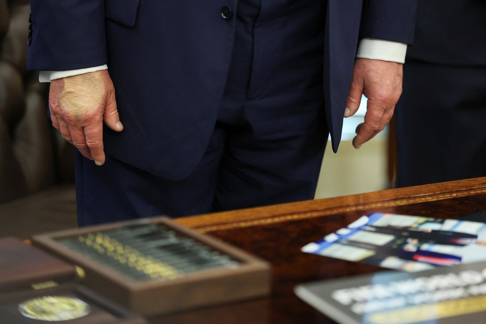Mão direita do presidente dos EUA, Donald Trump, é vista com maquiagem durante evento na Casa Branca, em 22 de agosto de 2025 — Foto: Jonathan Ernst/Reuters