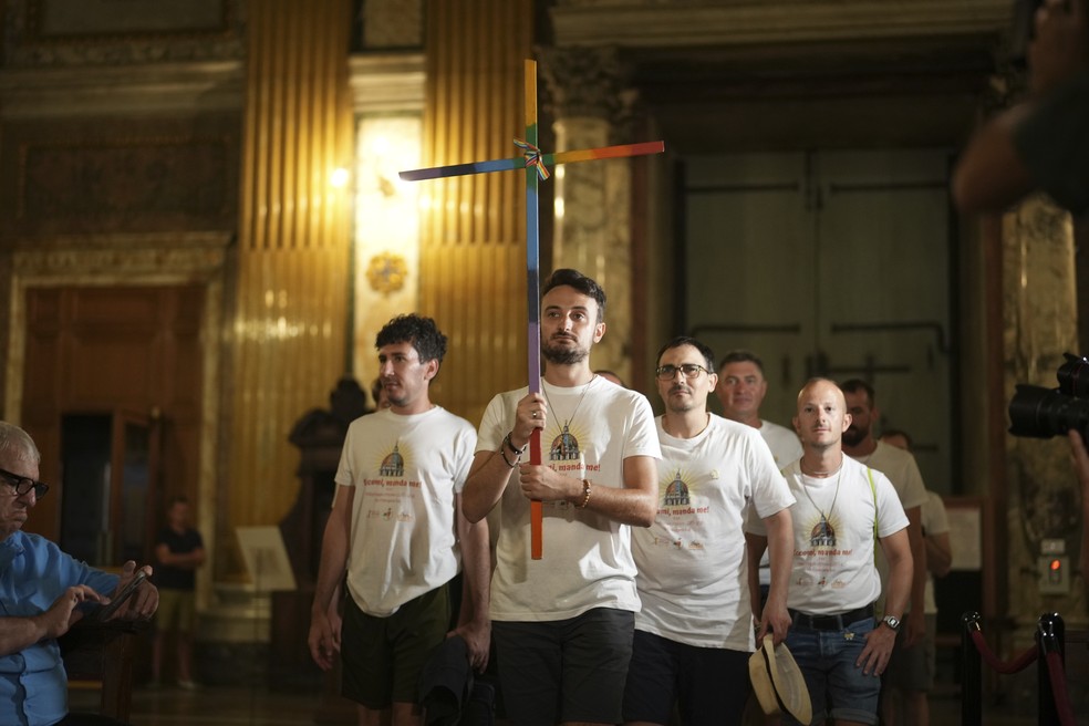 Andrea Mattei, segurando uma cruz, chega acompanhado de outros membros da comunidade LGBTQIA+ — Foto: AP Photo/Andrew Medichini