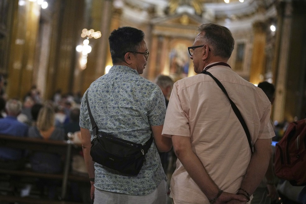 Justin Del Rosario (esq.) e John Capozzi participam de vigília da comunidade LGBTQIA+ na Igreja de Jesus — Foto: AP Photo/Andrew Medichini