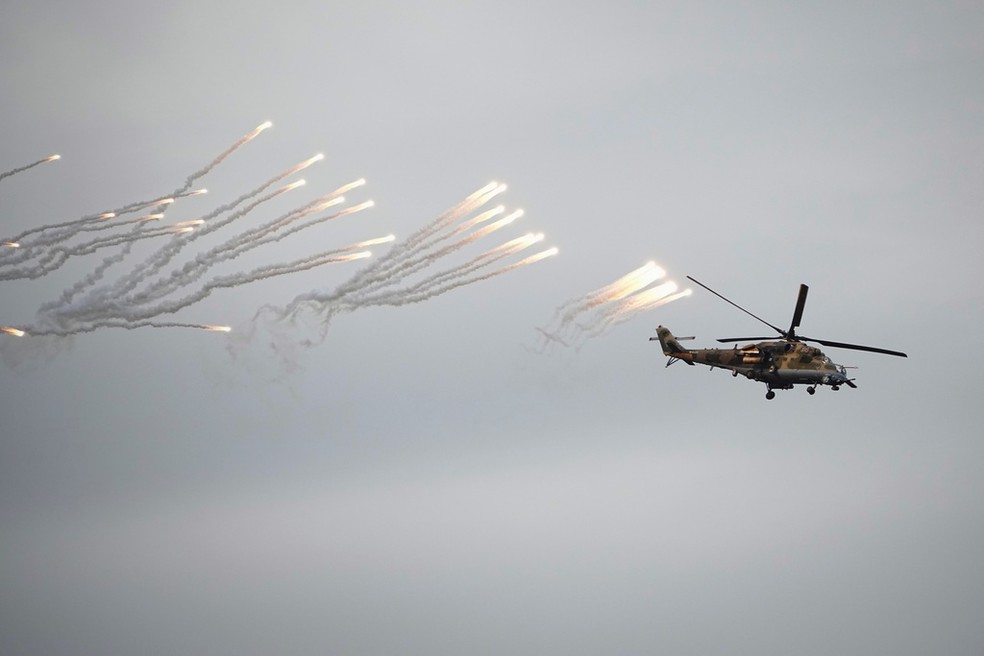 Helicóptero belarusso faz disparos em exercícios militares conjuntos com a Rússia em Belarus, em 15 de setembro de 2025. — Foto: Pavel Bednyakov/ AP