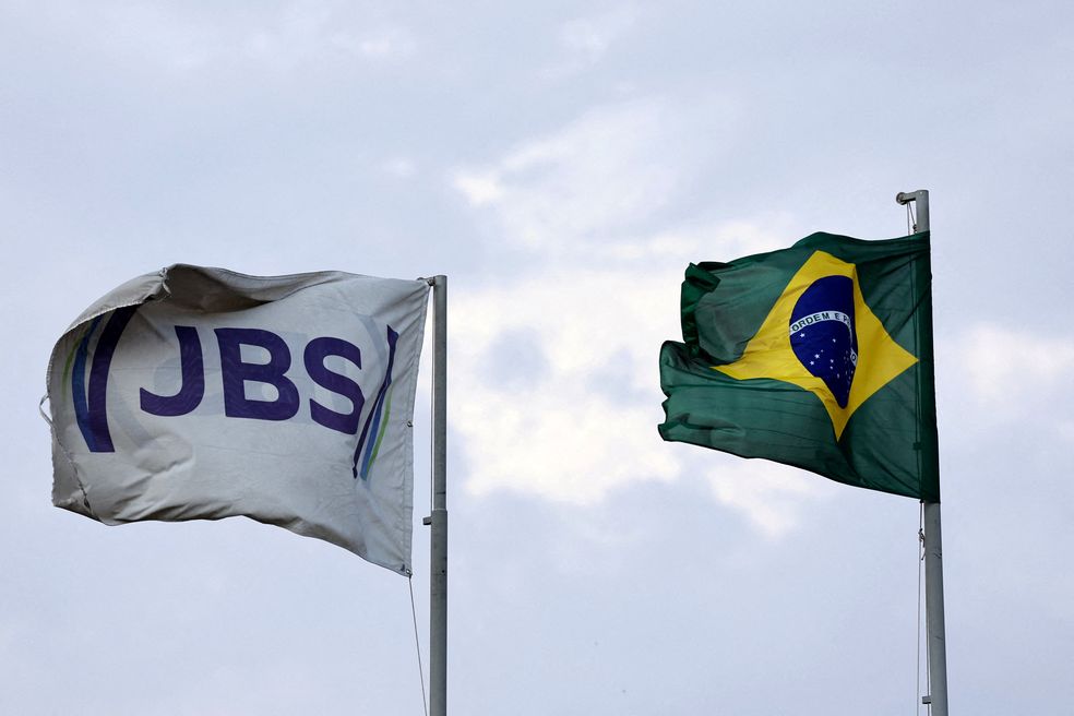 As bandeiras da JBS S.A., a maior produtora de carne bovina do mundo, e a do Brasil tremulam em uma unidade da JBS, em Santa Maria das Barreiras, no estado do Pará, Brasil, em 12 de setembro de 2025. — Foto: REUTERS/Amanda Perobelli/Foto de arquivo