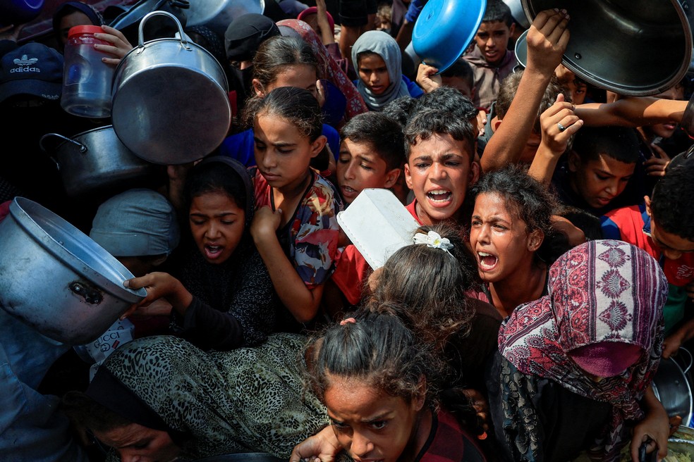 FOTO DE ARQUIVO: Palestinos aguardam para receber comida de uma cozinha beneficente, em Khan Younis, sul da Faixa de Gaza, 21 de agosto de 2025. — Foto: Reuters/Hatem Khaled/Foto de arquivo