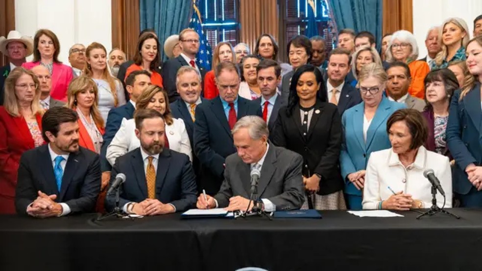 O governador do Texas, Greg Abbott, assina o projeto de lei em cerimônia. — Foto: Gabinete do Governador do Texas, via BBC