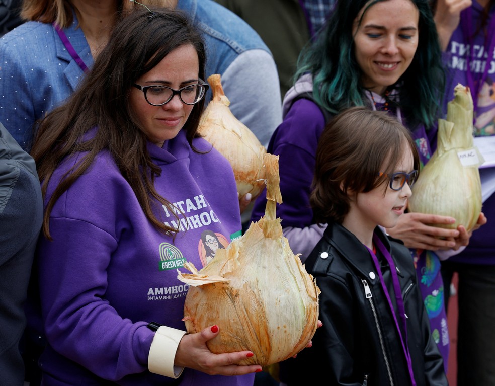 Mulher segura uma cebola gigante na competição russa de vegetais grandes em Moscou — Foto: REUTERS/Yulia Morozova