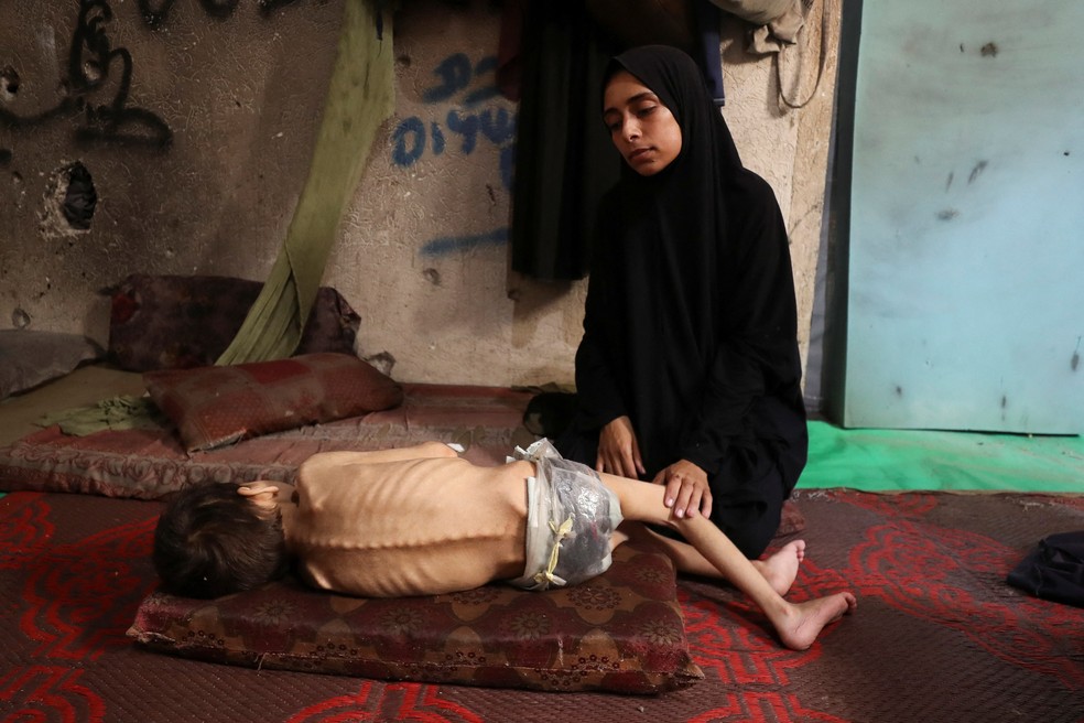 Fome extrema: mãe palestina Samah Matar ao lado de seu filho desnutrido Youssef, que sofre de paralisia cerebral, em uma escola onde eles se abrigam na Cidade de Gaza, em 24 de julho de 2025. — Foto: Mahmoud Issa/Reuters