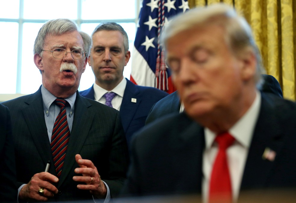 Na foto, de fevereiro de 2019, Trump aparece assinando um memorando com John Bolton, agora ex-conselheiro de segurança nacional, ao fundo (de óculos). — Foto: Leah Millis/Reuters