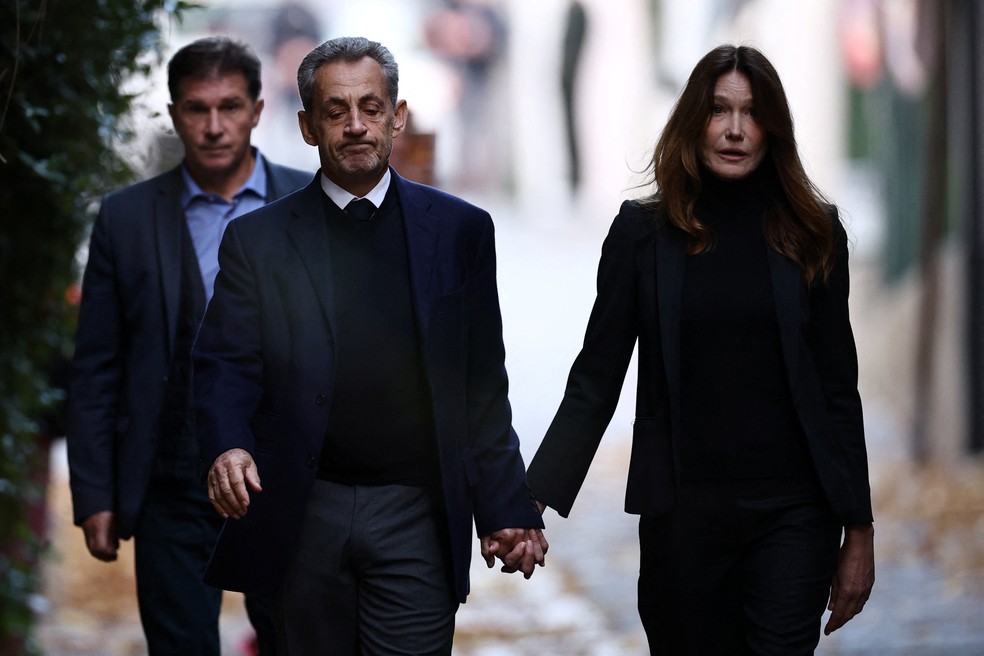 Ex-presidente francês Nicolas Sarkozy deixa sua casa com a esposa Carla Bruni para ir à prisão e começar a cumprir pena de cinco anos — Foto: Sarah Meyssonnier/Reuters