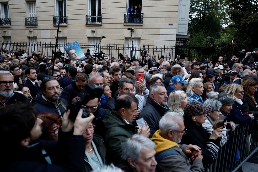 Pessoas seguram um cartaz com o retrato de Nicolas Sarkozy e o slogan “França Forte” durante um ato convocado pelos filhos do ex-presidente, em apoio ao pai. — Foto: Benoit Tessier/Reuters