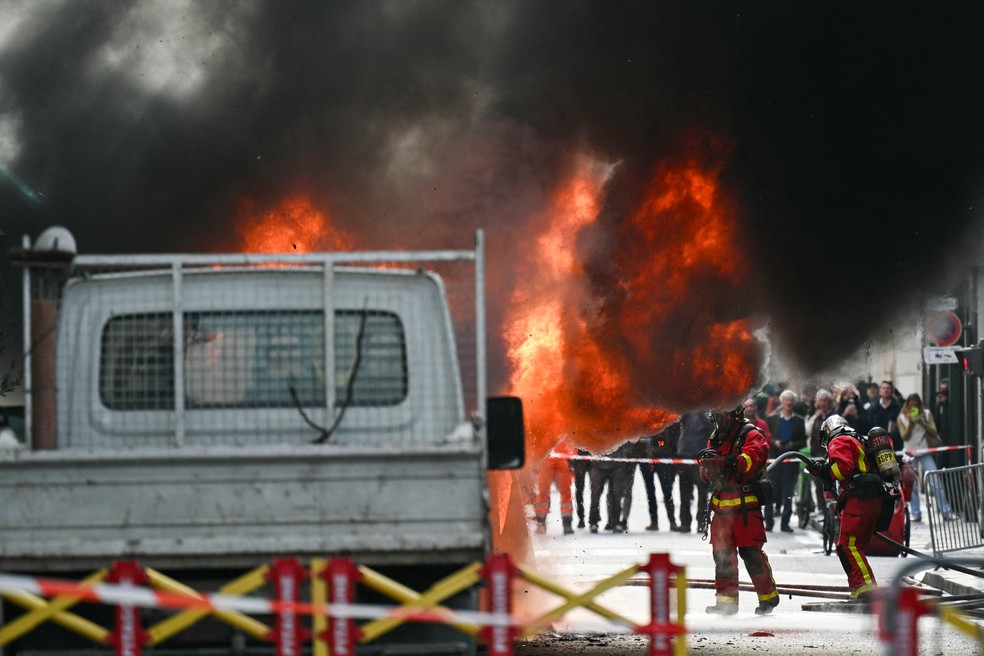 Bombeiros trabalham para combater fogo em van na Rua de Varenne, em Paris, no dia 7 de outubro de 2025 — Foto: Bertrand Guy/AFP
