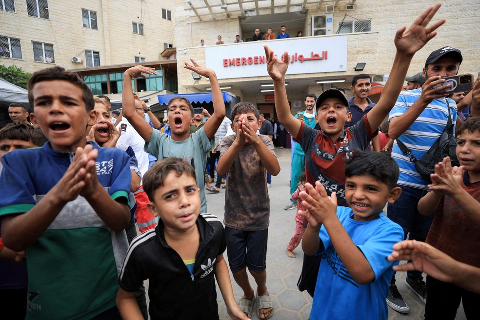 Crianças palestinas comemoram em frente a hospital no centro da Faixa de Gaza — Foto: REUTERS/Dawoud Abu Alkas