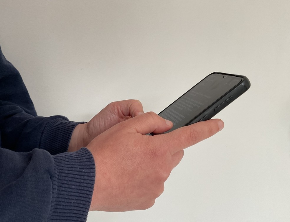 Pessoa olha aplicativo de mensagens no celular — Foto: Joana Caldas/g1