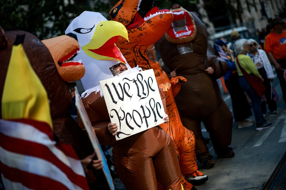 Pessoas usam fantasias infláveis ​​durante um protesto "No Kings", na Califórnia — Foto: REUTERS/Carlos Barria