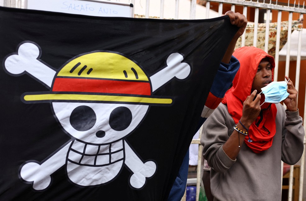 Um manifestante usa uma máscara enquanto olha perto de uma bandeira de 'One Piece' durante um protesto em Madagascar, em 3 de outubro de 2025 — Foto: Siphiwe Sibeko/Reuters