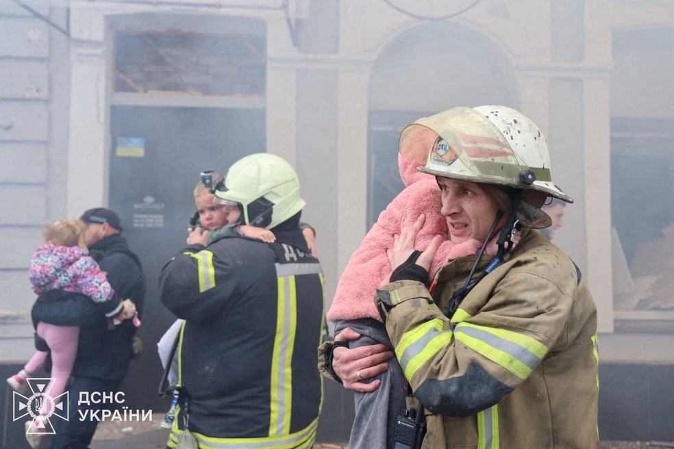 Bombeiros evacuam crianças de jardim de infância atingido por bombardeio russo em Kharkiv, na Ucrânia, em 22 de outubro de 2025. — Foto: Serviço de emergências da Ucrânia/Handout via REUTERS