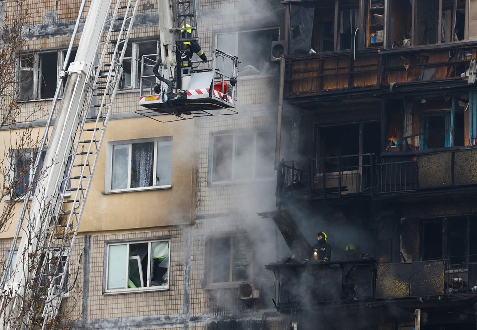 Profissionais dos serviços de emergência trabalham em um prédio residencial danificado durante um ataque russo com mísseis e drones contra Kyiv, em meio ao ataque da Rússia à Ucrânia, em 29 de novembro de 2025 — Foto: REUTERS/Valentyn Ogirenko
