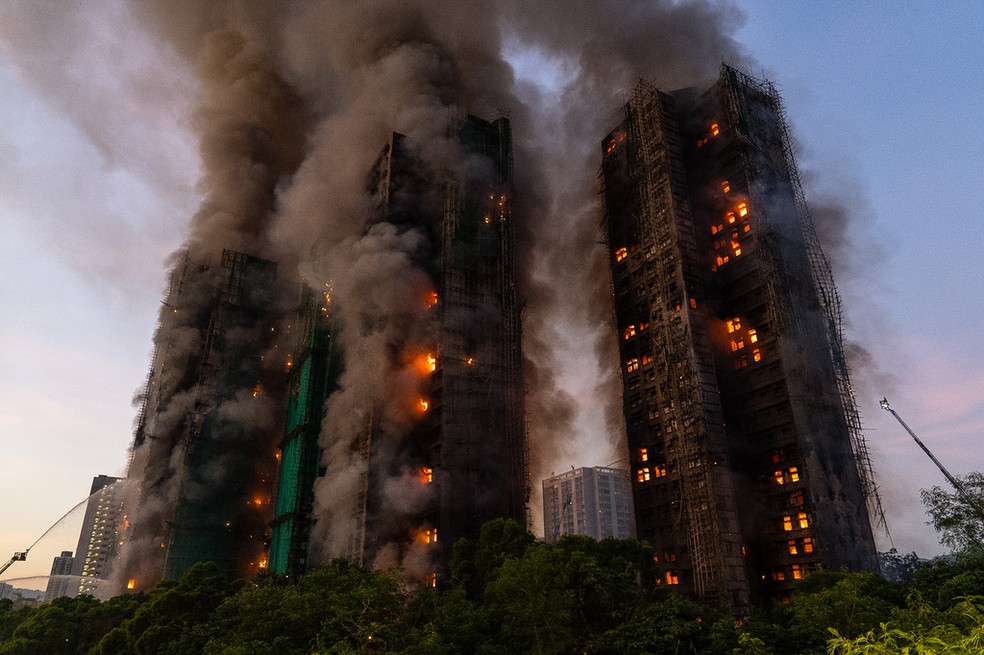 As chamas se espalharam por várias torres e apartamentos, e uma enorme coluna de fumaça tomou o céu de Hong Kong — Foto: AP Photo/Chan Long Hei