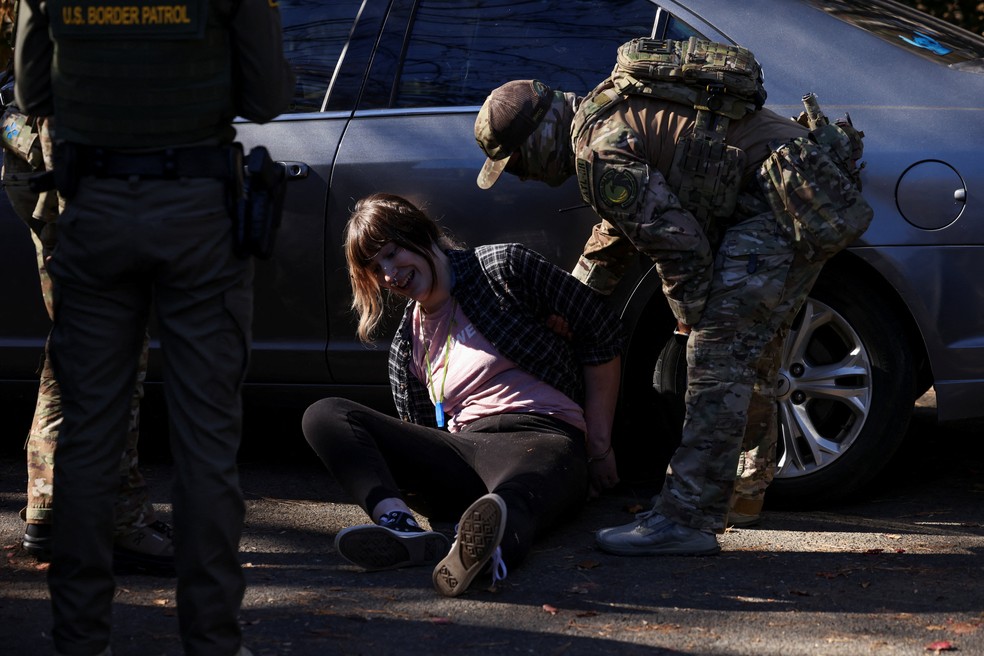 Manifestante é detida durante operação do ICE em CHarlotte, na Carolina do Norte, em 17 de novembro de 2025 — Foto: REUTERS/Sam Wolfe