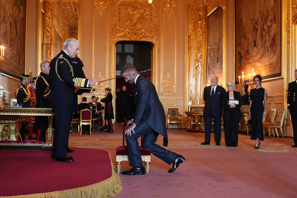 Ex-jogador de futebol David Beckham recebe o título de cavaleiro do rei Charles III em cerimônia no castelo de Windsor, no Reino Unido, em 4 de novembro de 2025. — Foto: Jonathan Brady/PA Media via AP