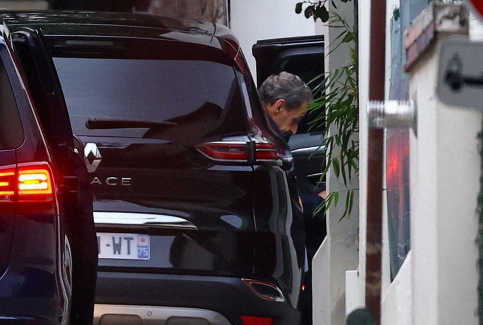 Ex-presidente da França Nicolas Sarkozy coloca o rosto para fora de seu automóvel ao voltar para sua residência após ser libertado da prisão, em 10 de novembro de 2025. — Foto: Yves Herman/ Reuters
