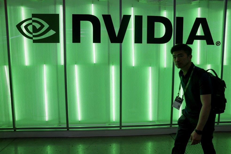 Pessoa passa por painel com logomarca da Nvidia na Computex em Taiwan em junho de 2024 — Foto: Ann Wang/Reuters