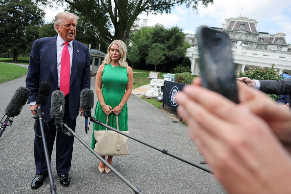 O presidente dos EUA, Donald Trump, fala com repórteres, enquanto a secretária de imprensa da Casa Branca, Karoline Leavitt, está ao lado dele, enquanto ele parte para viajar para a Pensilvânia, do gramado sul da Casa Branca em Washington — Foto: REUTERS/Jonathan Ernst