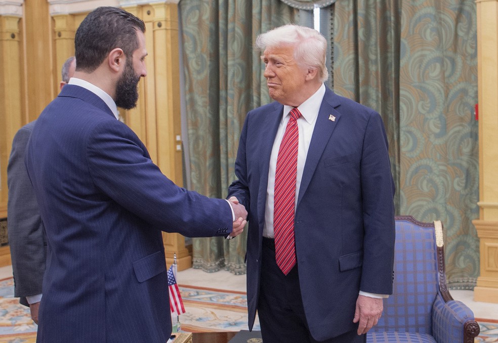 O presidente dos EUA, Donald Trump, cumprimenta o presidente inteirino sírio, Ahmed al-Shaara, em Riade, na Arábia Saudita, em 14 de maio de 2025. — Foto: Bandar Aljaloud/ Palácio Real da Arábia Saudita via AP