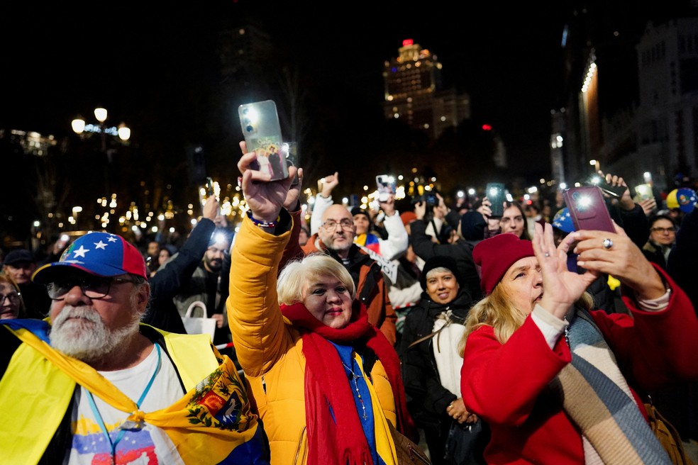 Pessoas acendem as lanternas de seus celulares enquanto venezuelanos residentes na Espanha se reúnem para uma marcha global em apoio à ganhadora do Prêmio Nobel da Paz, Maria Corina Machado, em Madri, Espanha, em 6 de dezembro de 2025. — Foto: REUTERS/Ana Beltran