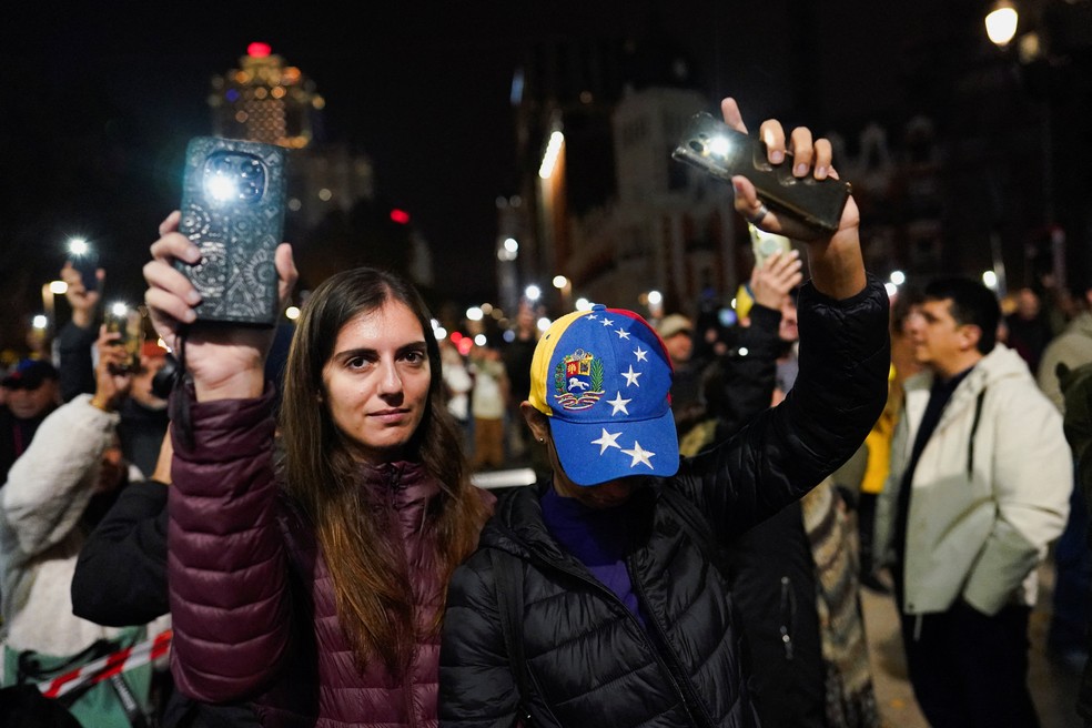 Pessoas acendem as lanternas de seus celulares enquanto venezuelanos residentes na Espanha se reúnem para uma marcha global em apoio à ganhadora do Prêmio Nobel da Paz, Maria Corina Machado, em Madri, Espanha, em 6 de dezembro de 2025. — Foto: REUTERS/Ana Beltran