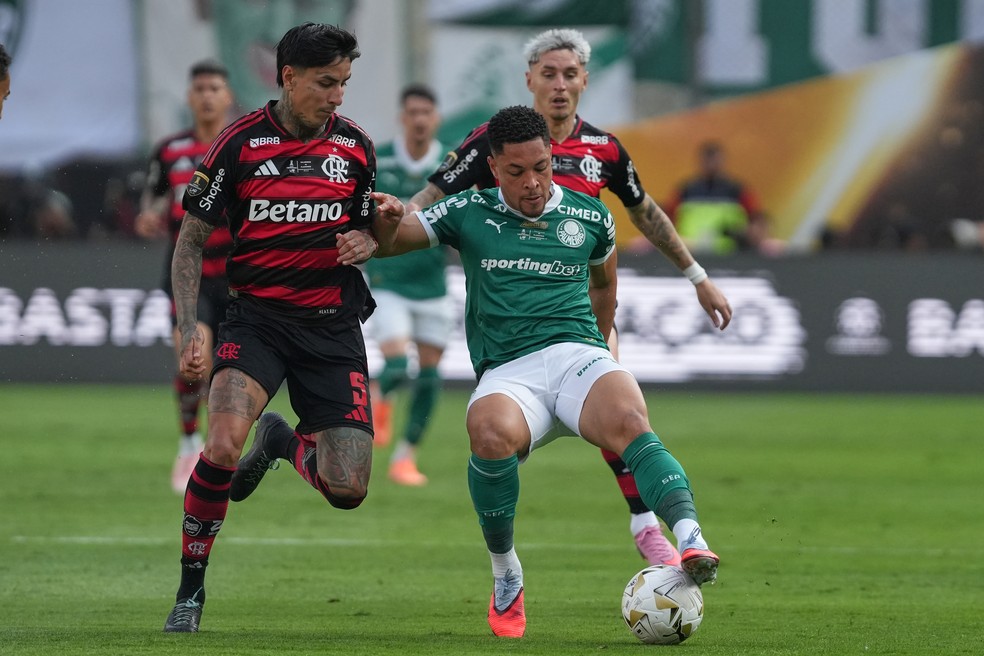 Vitor Roque, do Palmeiras, à direita, e Erick Pulgar, do Flamengo, disputam a bola durante a final da Copa Libertadores, realizada em Lima, Peru, em 29 de novembro de 2025. — Foto: AP Photo/Guadalupe Pardo