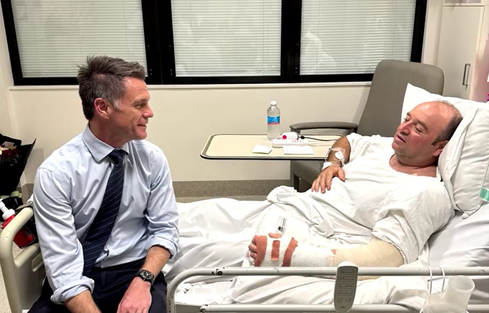 Ahmed al Ahmed, de 43 anos, na cama de um hospital conversando com o premiê do estado australiano de Nova Gales do Sul, em 15 de dezembro de 2025. — Foto: Divulgação/Chris Minns no X