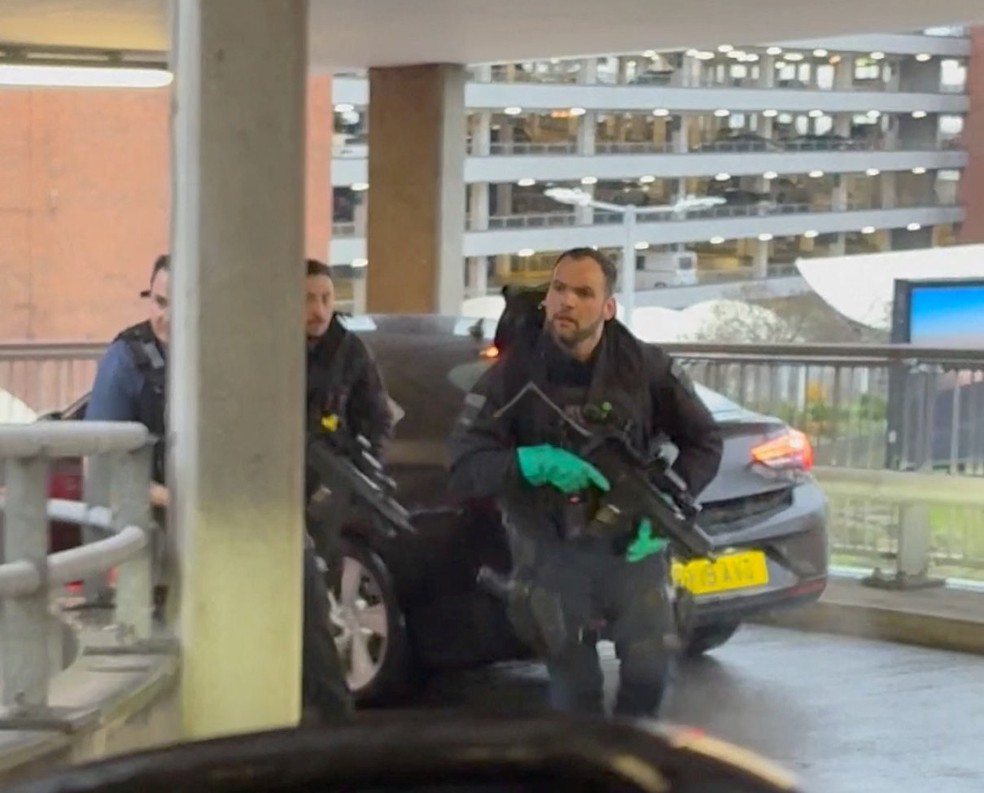 Policiais respondem após um incidente no Aeroporto de Heathrow, visto através do para-brisa de um carro, em Londres, Reino Unido, em 7 de dezembro de 2025, nesta imagem obtida de um vídeo publicado nas redes sociais — Foto: Tom Bate/Reuters