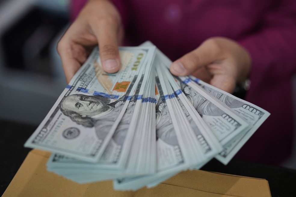 Funcionário de banco em Jacarta, na Indonésia, conta notas de dólar, em 10 de abril de 2025. — Foto: Tatan Syuflana/ AP